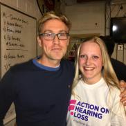 Russell Howard on the left wearing a blue jumper and glasses, on the right is me wearing white AOHL tshirt, both smiling